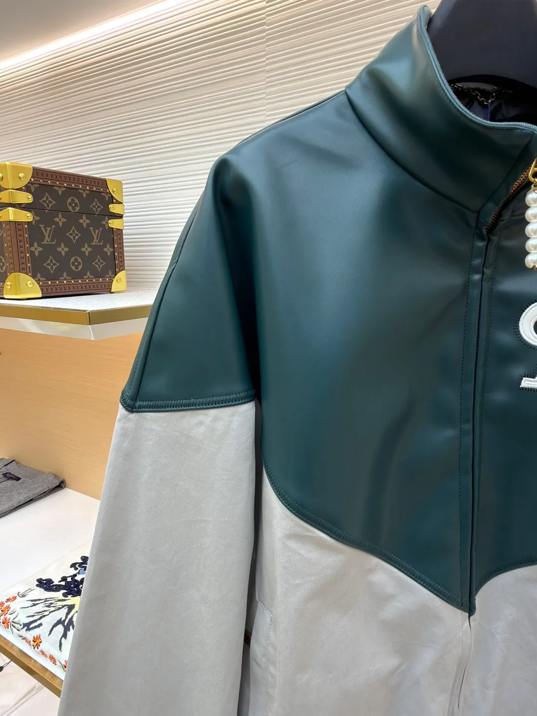 LOUIS VUITTON color-blocked sports long-sleeved jacket ●Original version: purchased and developed by 35590 ●Item number: 1681459-B80 ●Fabric: leather fabric ●Technology: intarsia production ●Color: gray-green splicing ●Version: fitted version ●Weight: about 800 grams ●Size: 46-48-50-52 ●Description: This jacket is made of high-quality genuine leather fabric. After special treatment, it feels soft and has a delicate luster. The contrasting color splicing design presents a fashionable layering. The stand-up collar structure is paired with a brand-customized metal zipper, and the zipper head is decorated with exquisite and luxurious pearls. The "LV" logo on the chest adopts three-dimensional leather embossing technology, with precise edge routing, strong three-dimensional effect and high recognition. The zipper pockets on both sides of the body are reinforced and sewn, which is practical and enhances the design. The splicing uses professional leather sewing technology, the stitch length is fine and even, and the ribbed design of the hem and cuffs fits the body shape. From the selection of genuine leather fabrics to the control of detailed craftsmanship, every process reflects LOUIS VUITTON's ultimate pursuit of craftsmanship precision and luxury style. It not only shows the high-end texture of leather items, but also highlights the brand design language through contrasting colors and three-dimensional logos. It is a fusion of leather craftsmanship and fashion design. The overall wiring is straight and delicate, the fabric is comfortable and soft, and the color is consistent without color difference. It can be matched with the same style to create a fashionable look and control various occasions. Customized accessories, complete with three standards, same style for men and women!